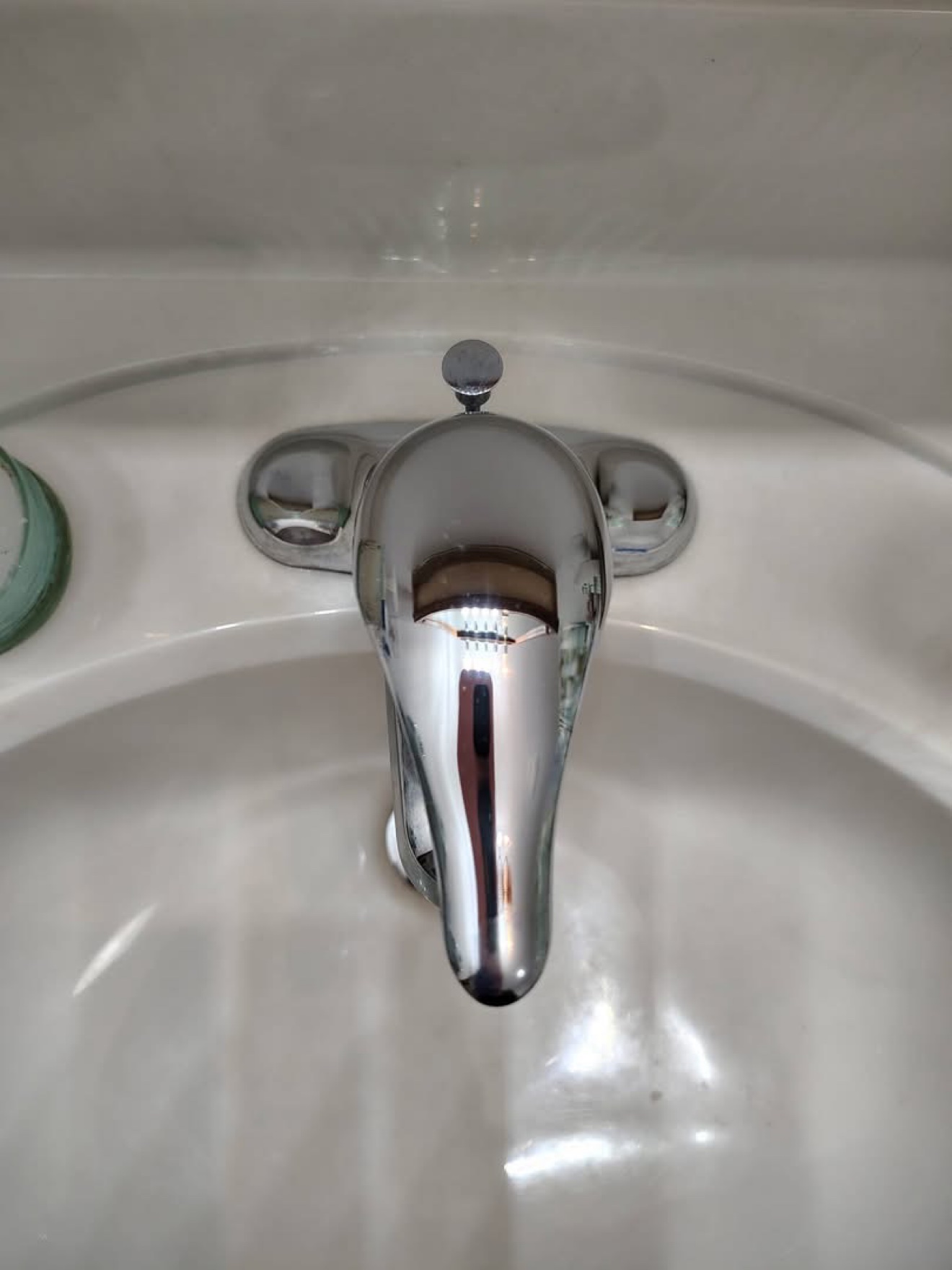 Same bathroom faucet gleaming after cleaning