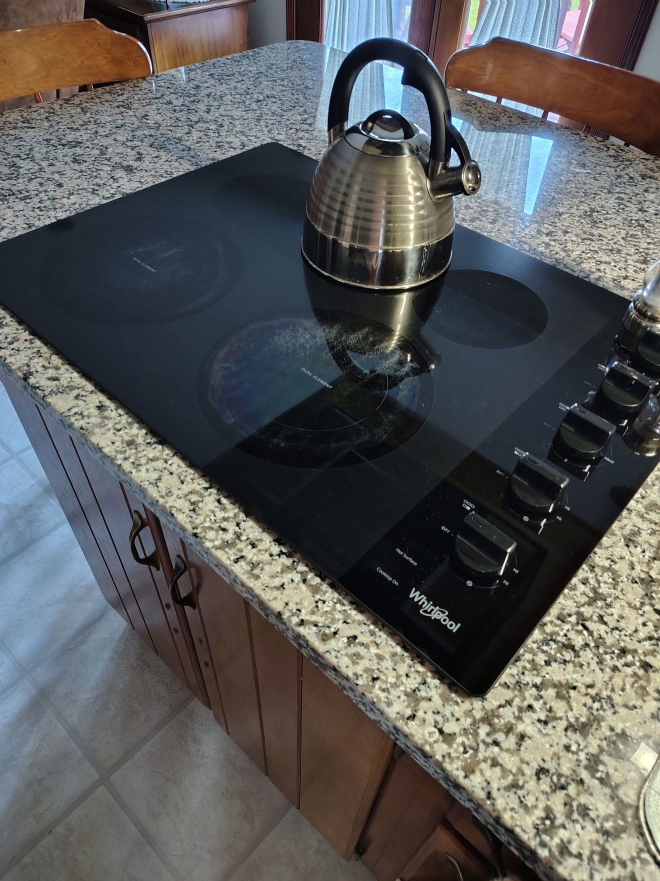 Gleaming glass stovetop with a kettle